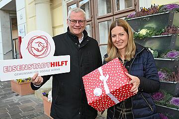 Bürgermeister Thomas Steiner und Renée Maria Wisak mit Geschenken in der Hand vor der Eisenstädter Rathaus